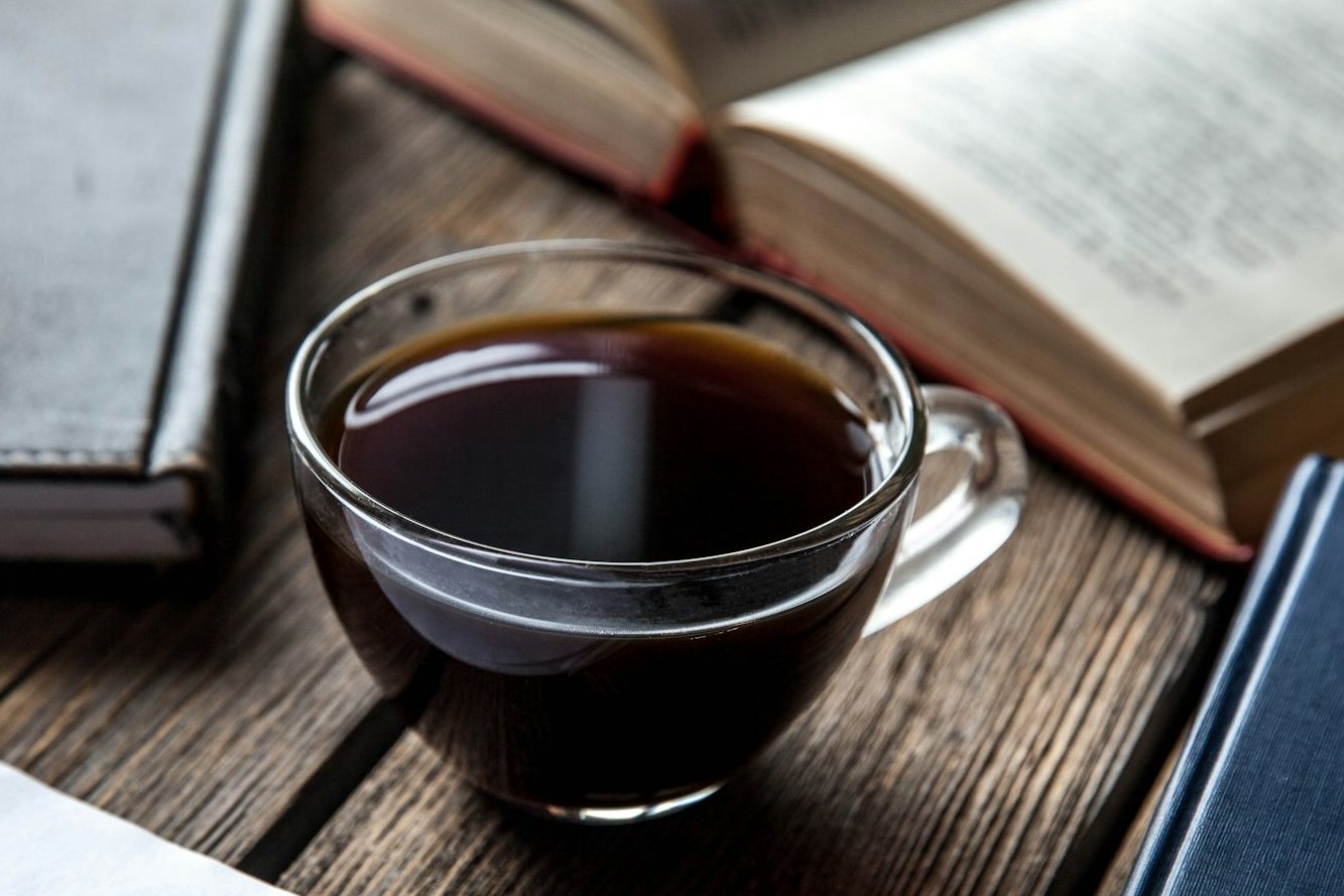 books and a cup of coffee on a wooden background