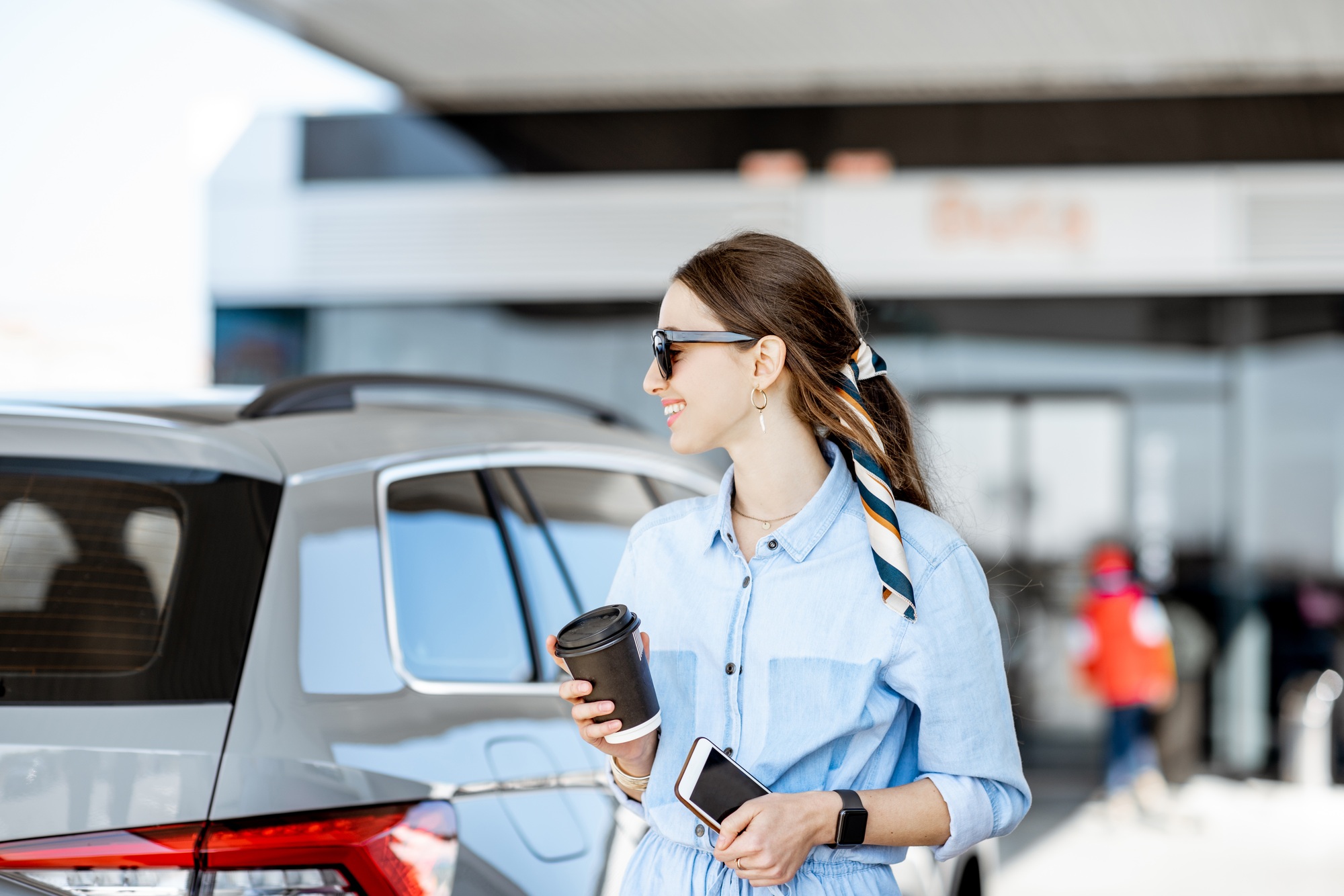 Woman with coffee on the gas station